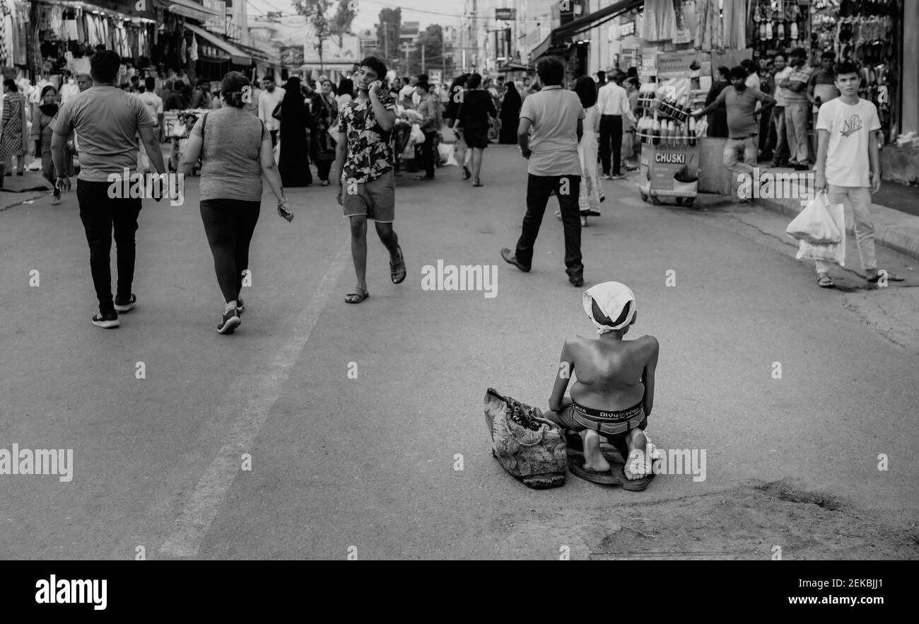 Cronicamente disabile povero uomo in cerca di elemosina lungo la strada in occupato mercato a Delhi, Uttar Prades Foto Stock