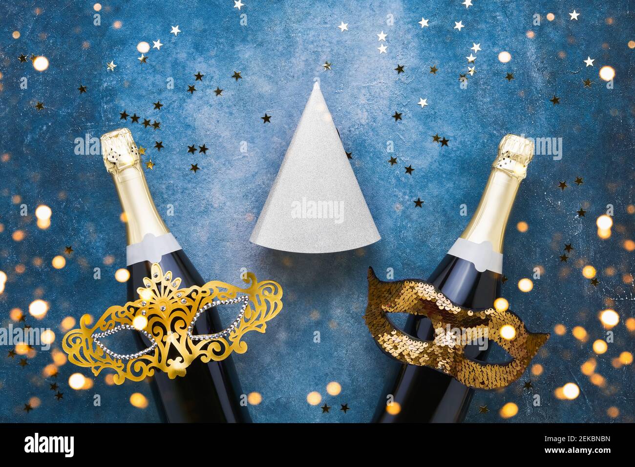 Festa ebraica Purim celebrazione sfondo con cappelli partito, maschera e champagne su uno sfondo blu. Disposizione piatta, spazio di copia Foto Stock