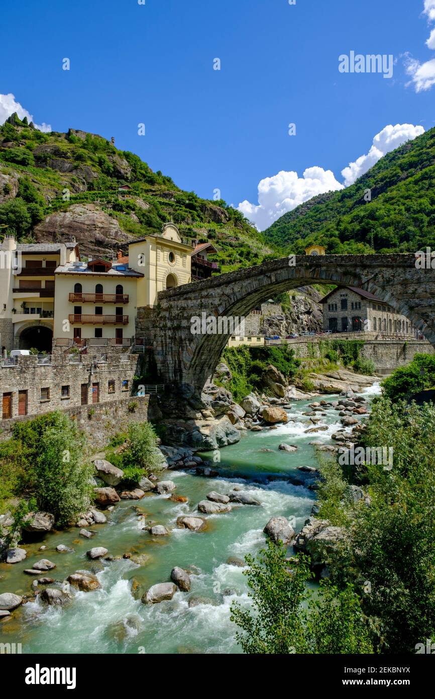 Italia, Pont-Saint-Martin, comune della Valle d'Aosta con ponte ad arco romano che si estende sul fiume Lys in primo piano Foto Stock