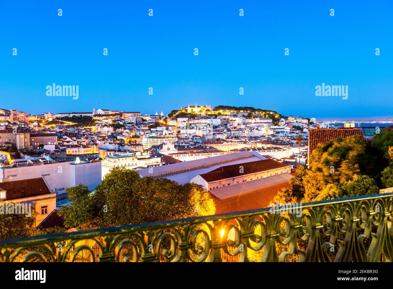 Portogallo, Lisbona, città illuminata al crepuscolo visto da Miradouro Sao Pedro Alcantara Foto Stock