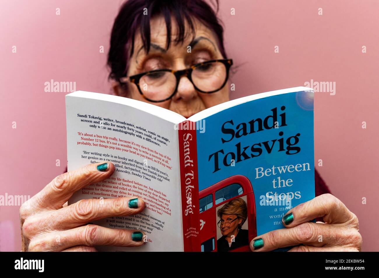 Donna che legge Sandi Toksvig tra il libro cartaceo di stop Foto Stock