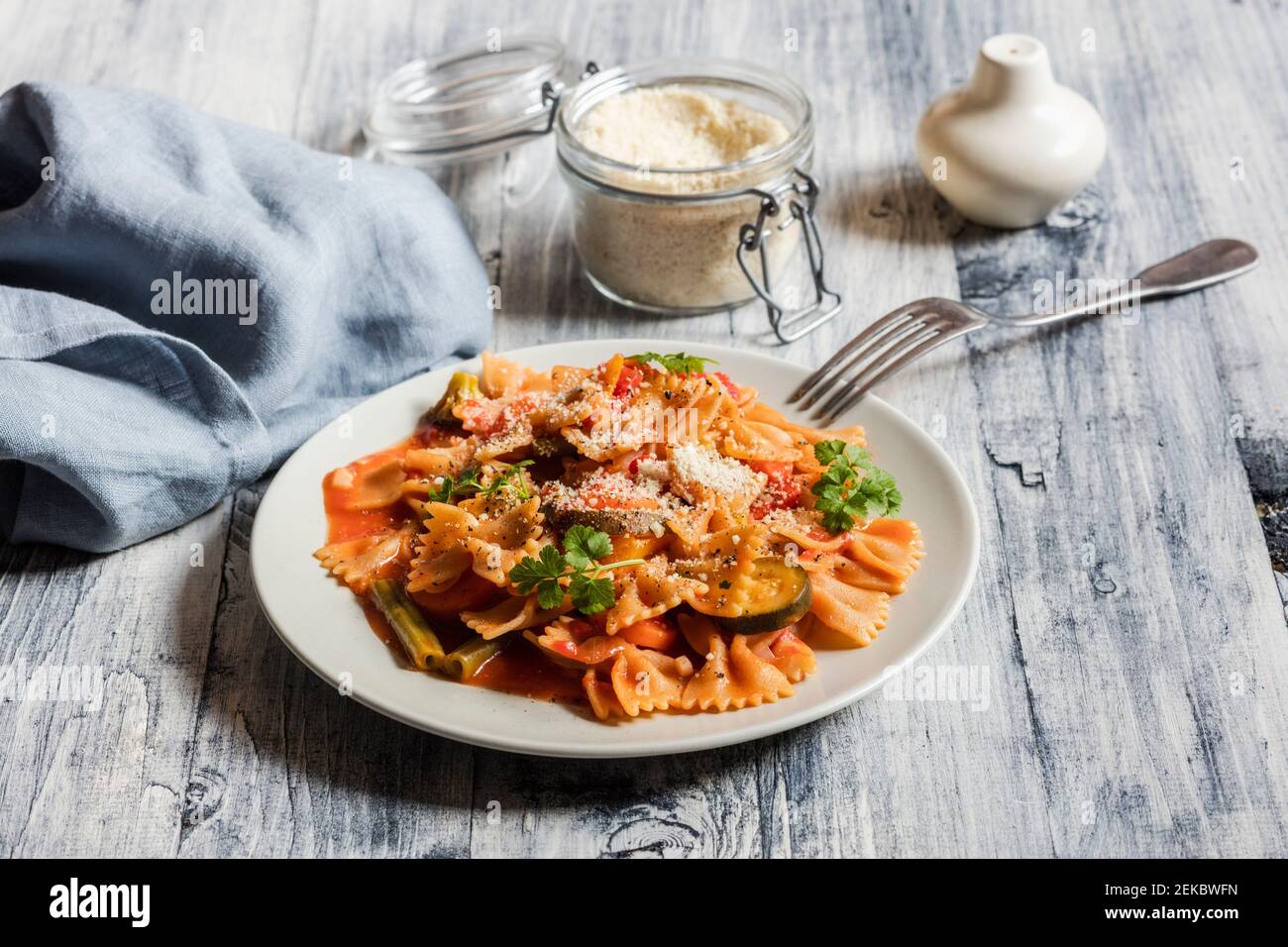 Due piatti di pasta con cravatta di prua con verdure e vegan Parmigiano Foto Stock