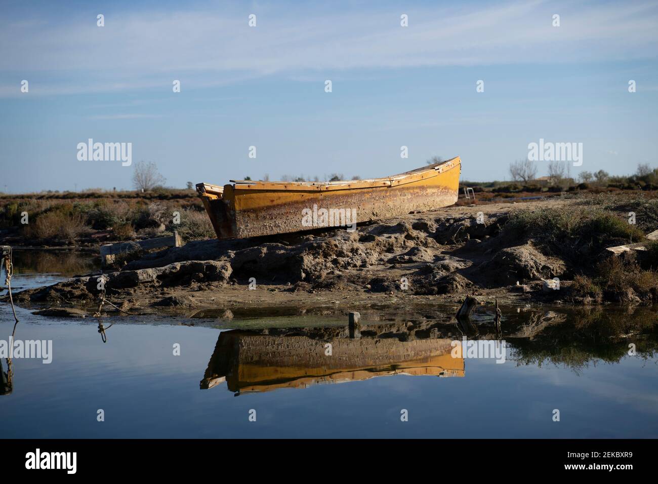 Barca abbandonata ormeggiata sulla riva del fiume contro il cielo al parco naturale, Ebro Delta, Spagna Foto Stock