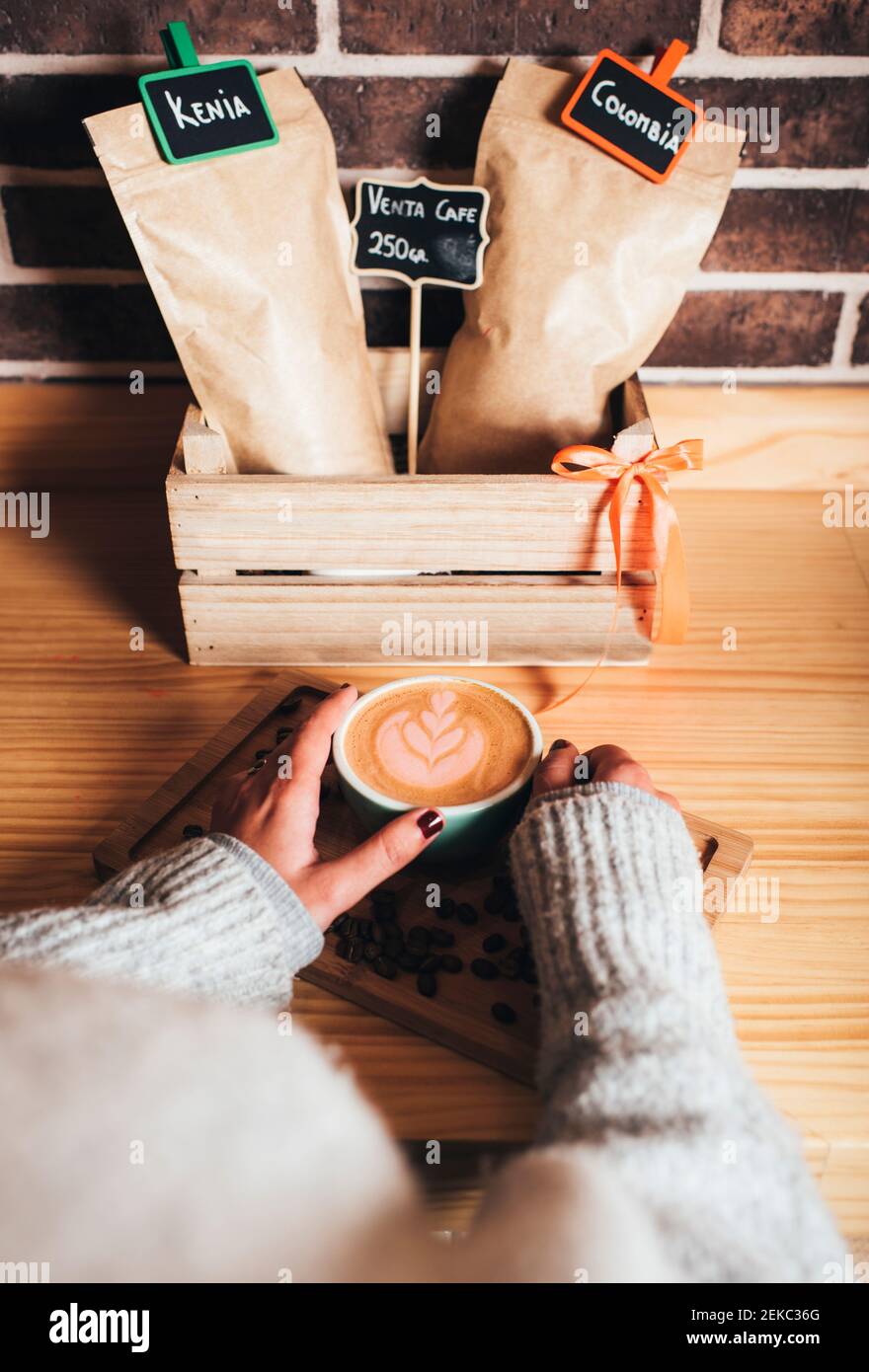 Donna che tiene una tazza di caffè con latte art al caffè Foto Stock