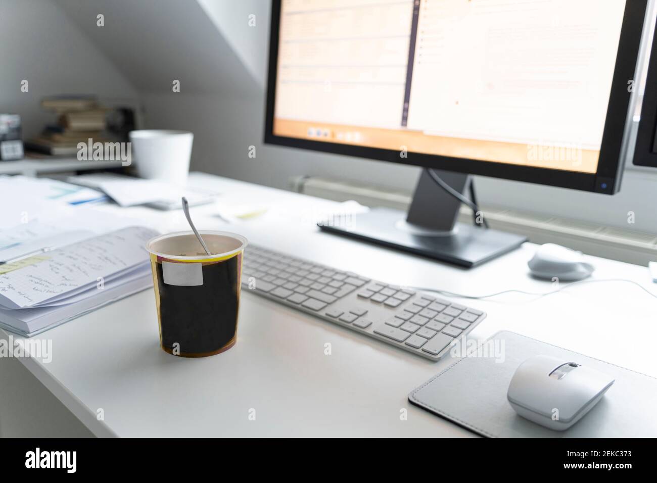 Computer con bicchiere e agenda sulla scrivania dell'ufficio di casa Foto Stock