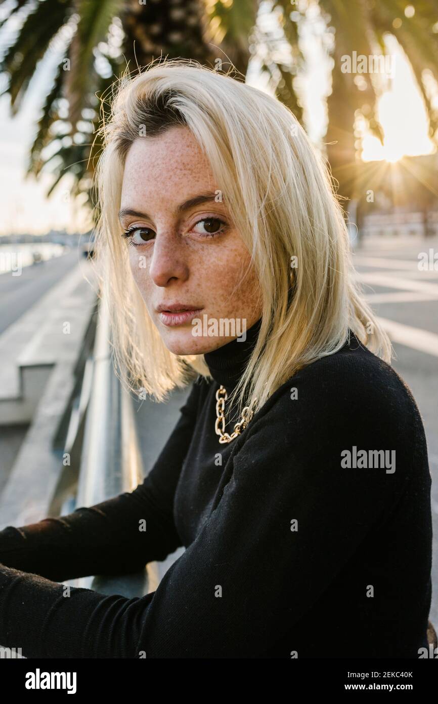 Giovane donna con capelli di media lunghezza appoggiati su ringhiera a. passeggiata Foto Stock