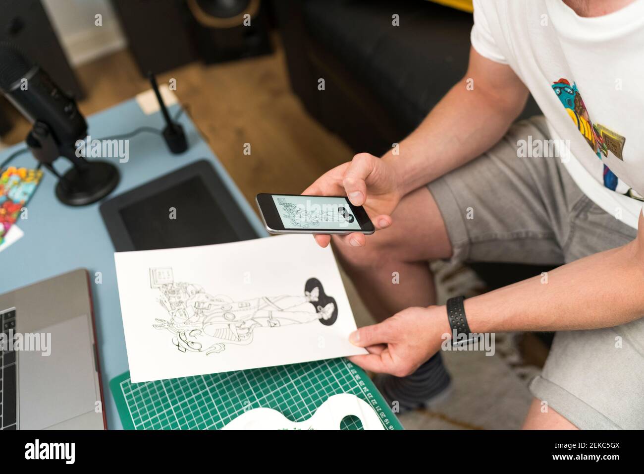 Artista che scatta foto di design tramite il telefono cellulare mentre si è seduti a. casa Foto Stock