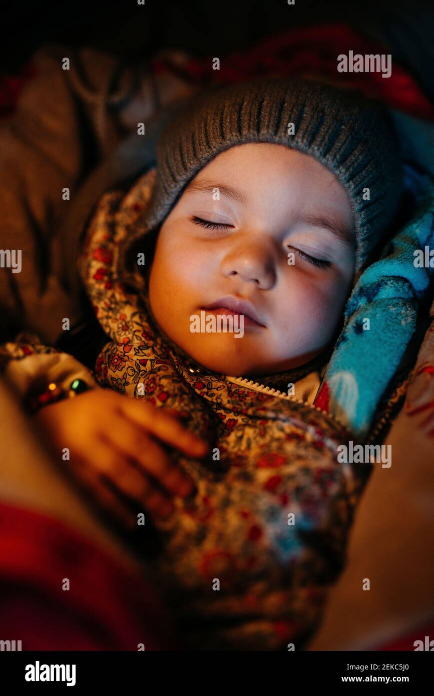 Bambina con cappello a maglia che dorme durante l'inverno Foto Stock