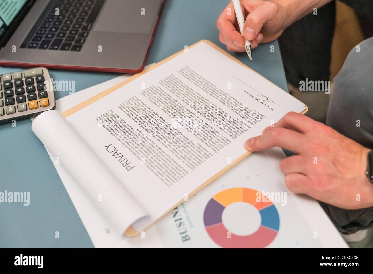 Uomo d'affari firma contratto di privacy mentre si siede a casa Foto Stock