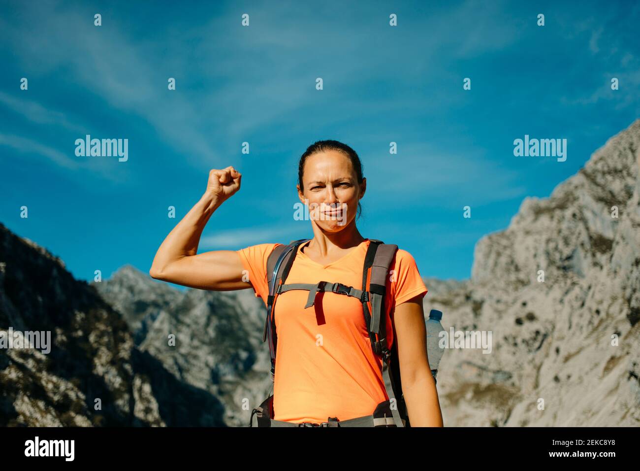 Escursionista che mostra i bicipiti mentre si trova in piedi contro il cielo al Cares Trail nel Parco Nazionale Picos De Europe, Asturias, Spagna Foto Stock