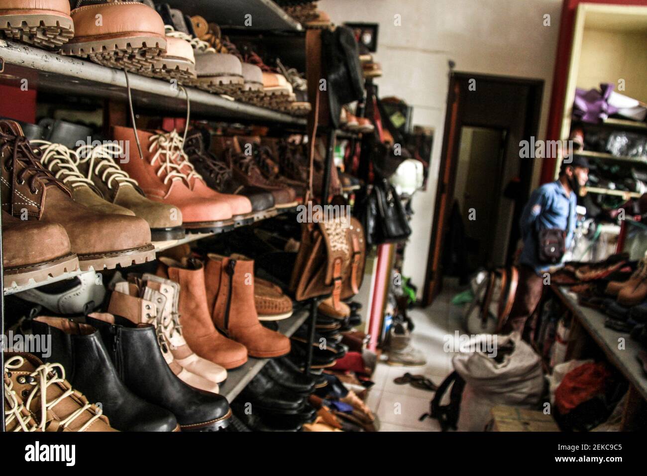 Collezione di scarpe in officina a Malang. Rini, il proprietario del  negozio di scarpe è costretto a fare la promozione e le vendite online  durante la pandemia di Covid-19 per mantenere l'azienda