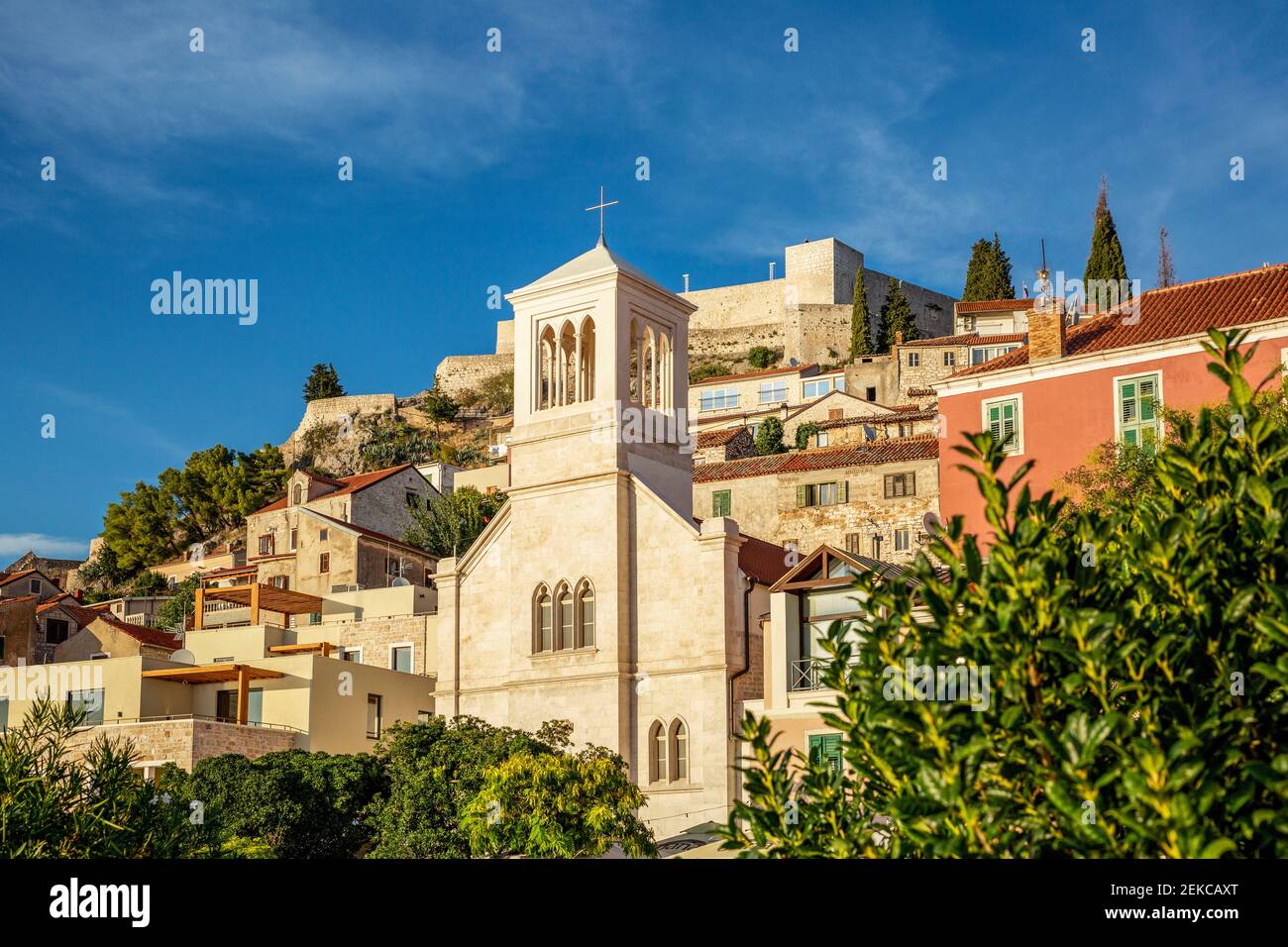 Croazia, Sibenik-Knin County, Sibenik, campanile della Chiesa con la Fortezza di San Giovanni in background Foto Stock
