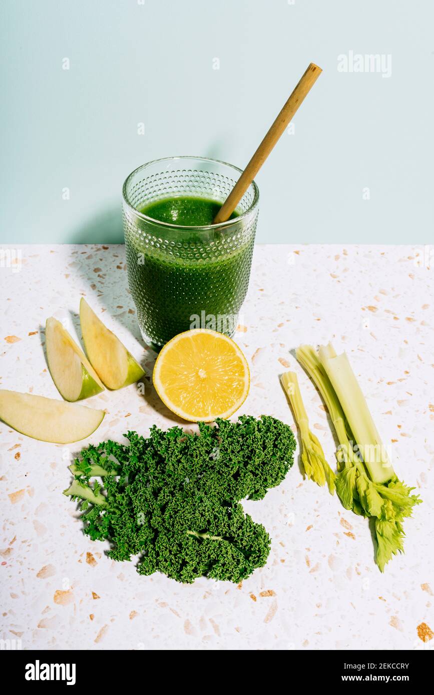 Succo verde estivo sano con mela, limone, kale e sedano contro il muro Foto Stock