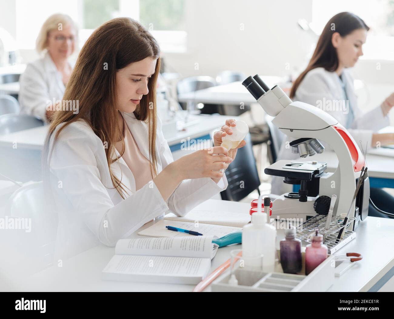 Ricercatori in camici bianchi che lavorano in laboratorio Foto Stock