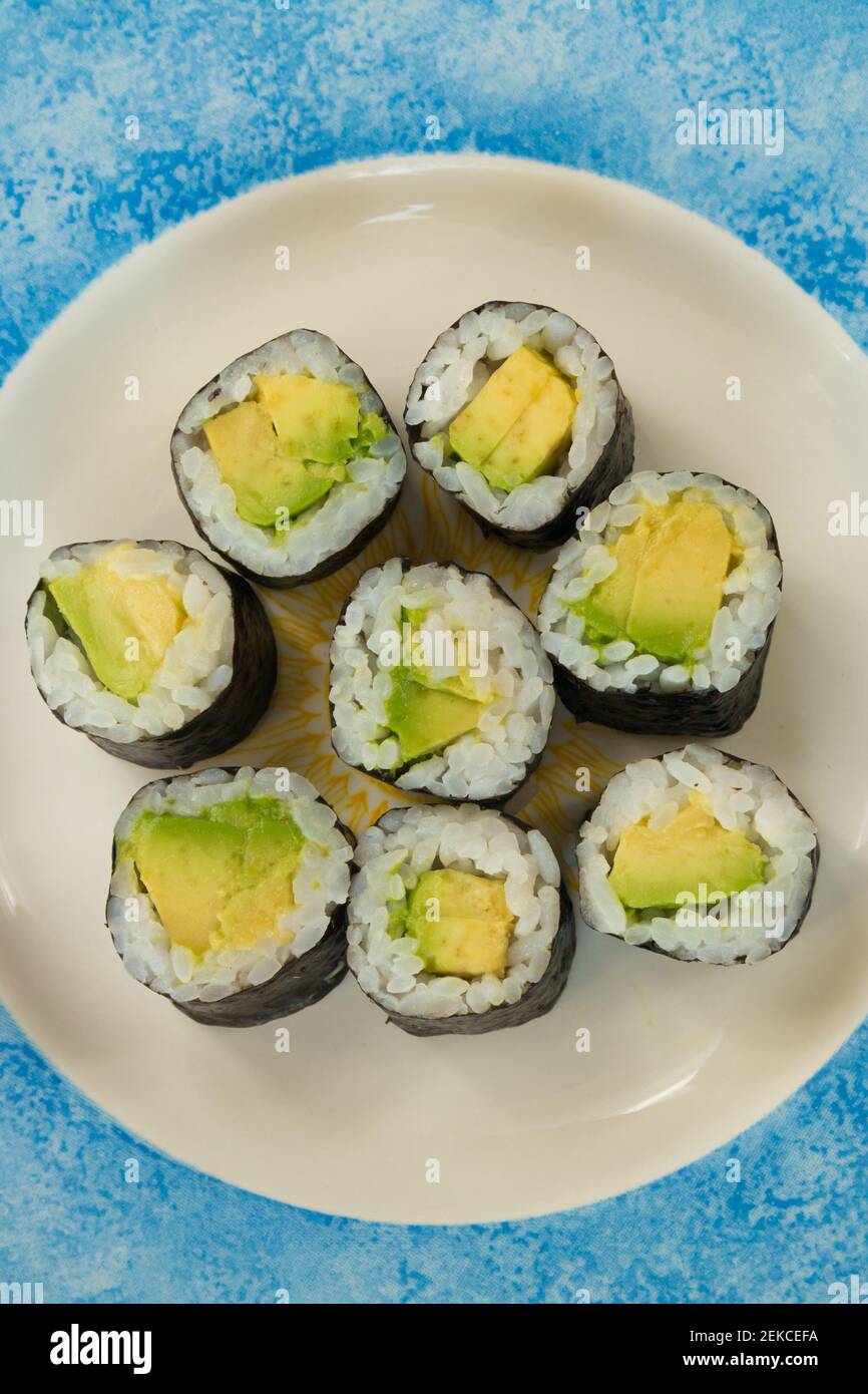 Sushi vegetariano con avocado su piatto bianco e blu Foto Stock