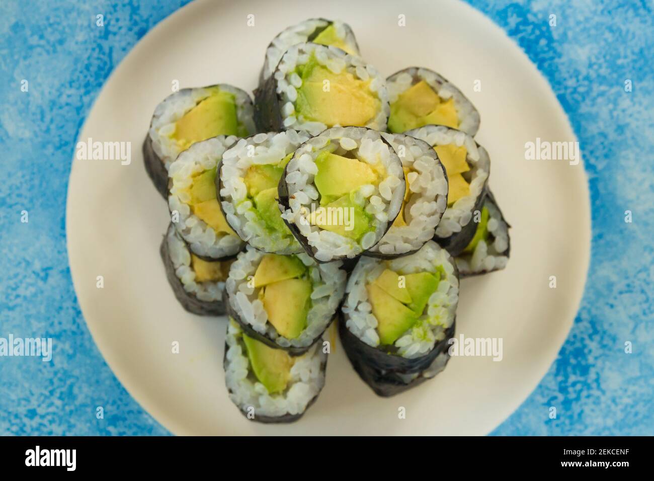 Sushi vegetariano con avocado su piatto bianco e blu isolato su sfondo bianco Foto Stock