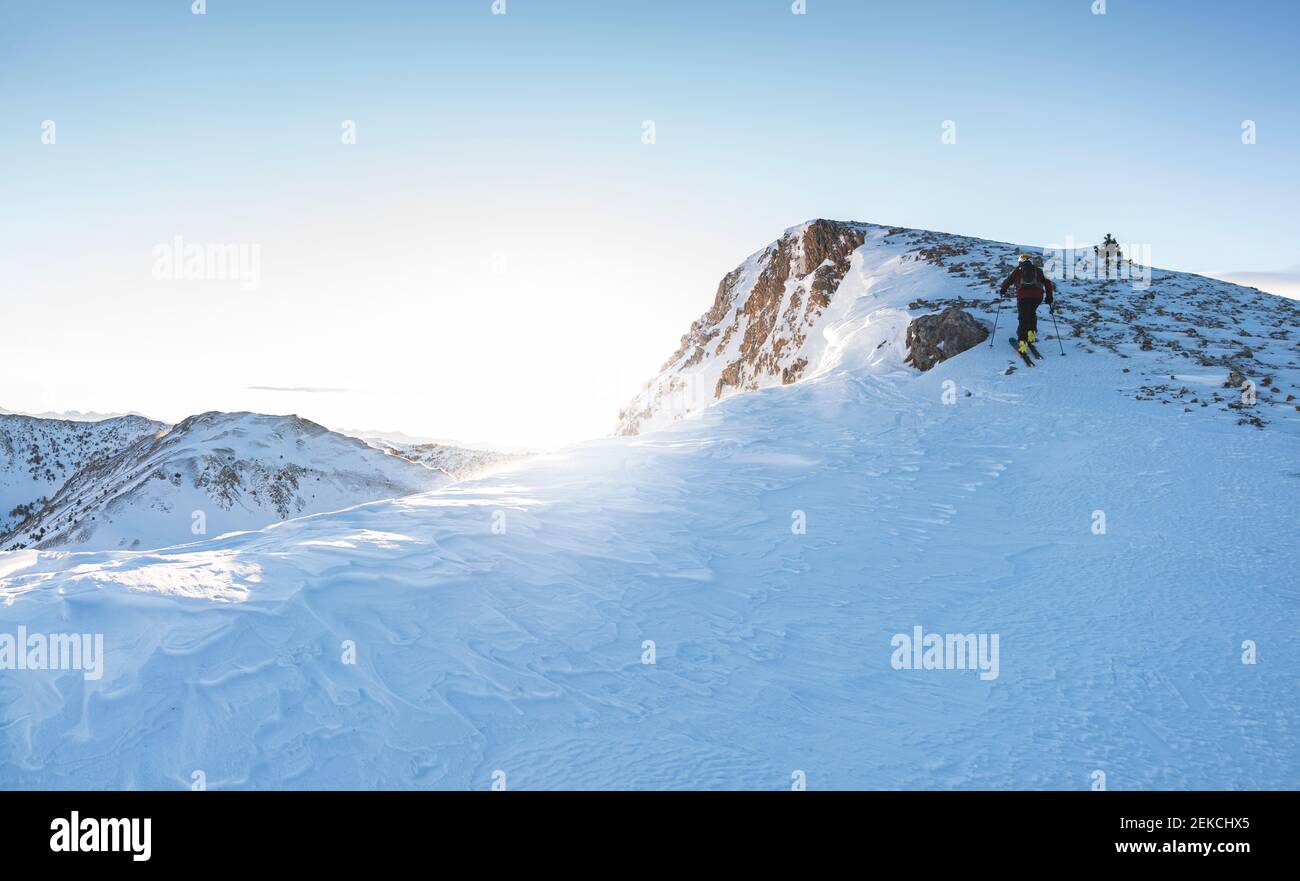 Sciatore maschile sulla cima della montagna innevata Foto Stock