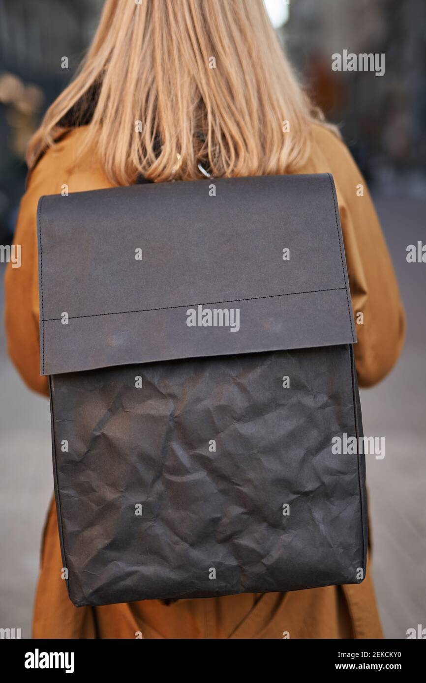 Zaino in carta nera senza sprechi su una trincea bionda di colore arancione. Concetto di carta eco moda o sacchetti zero rifiuti Foto Stock