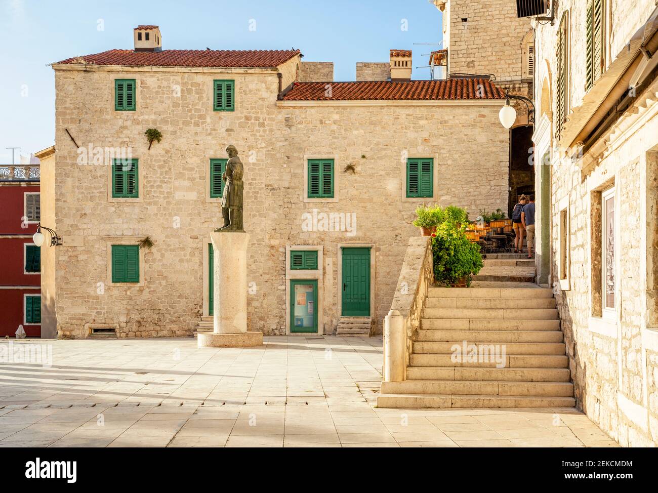 Croazia, Sibenik-Knin County, Sibenik, passi che portano alla costruzione in piedi sulla piazza Trg Republike Hrvatske con la statua sullo sfondo Foto Stock