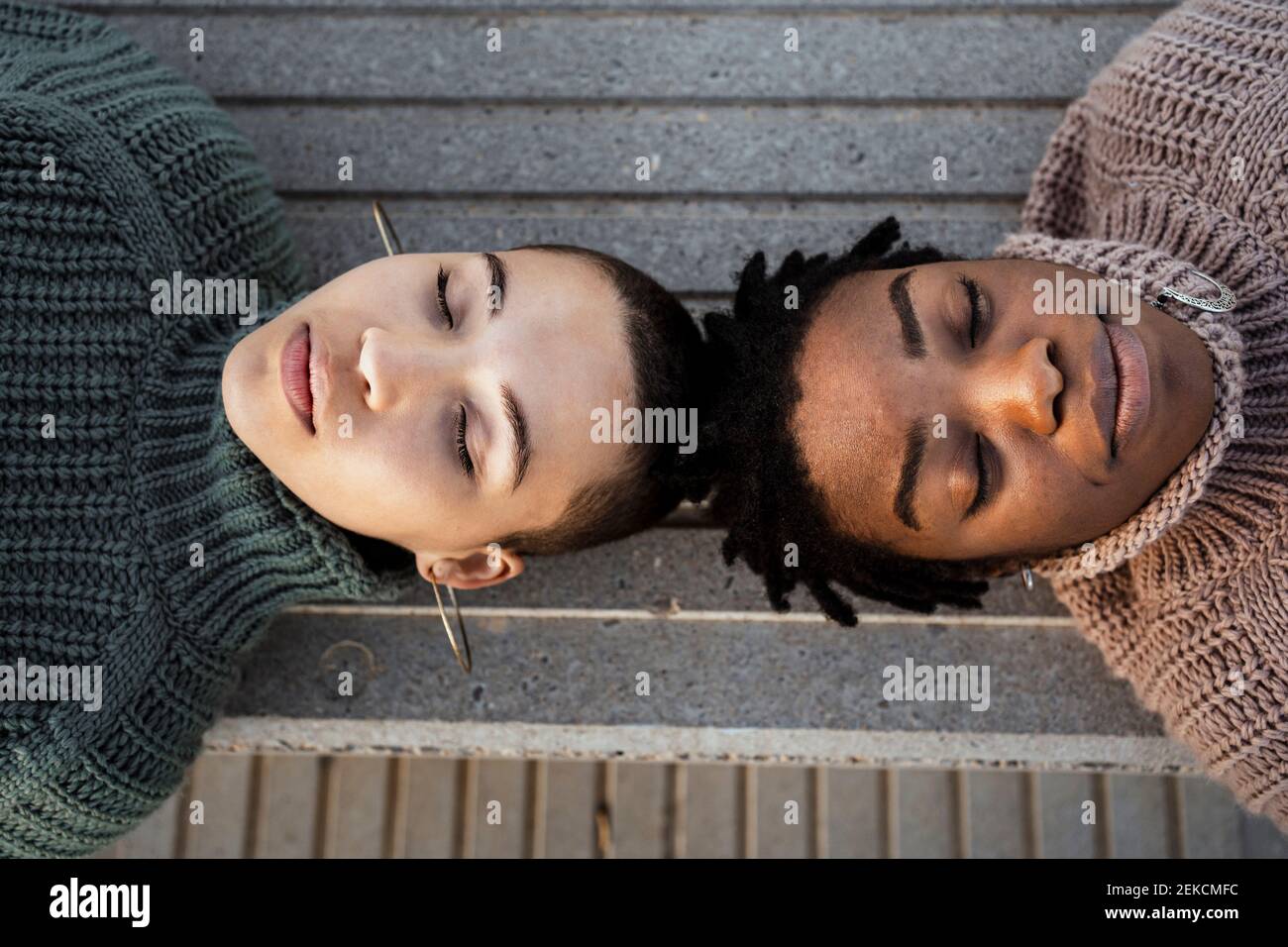 Giovani donne che riposano mentre si stendano sulla panchina Foto Stock