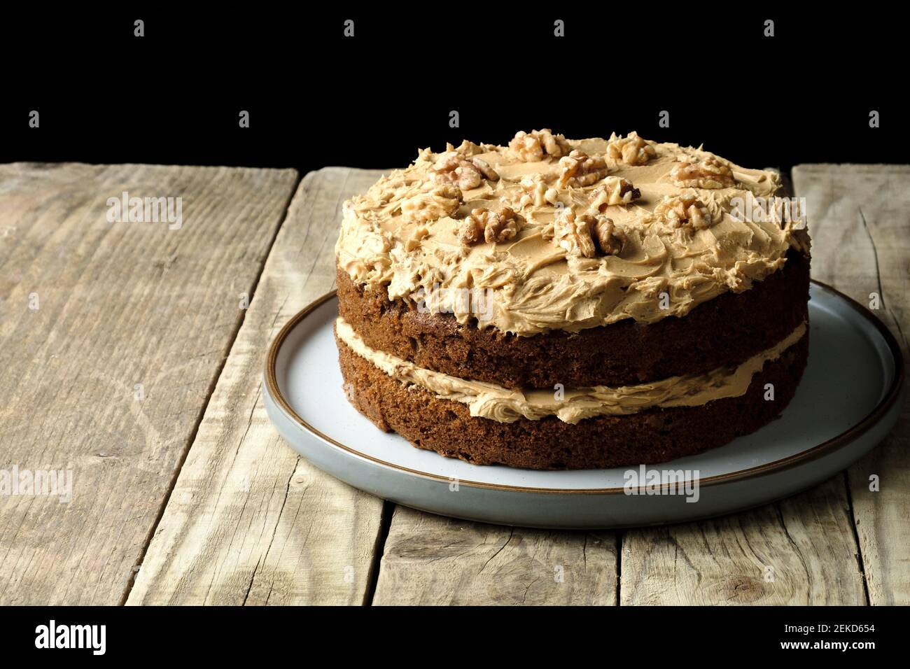 Una tradizionale torta di noci e caffè fatta in casa. La torta è condita generosamente con crema di burro e noci. Foto Stock