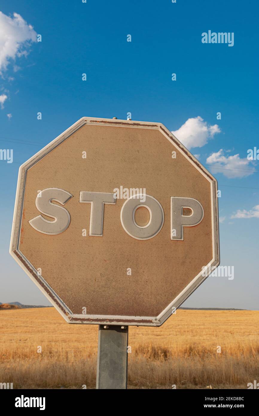 Il vecchio segnale di stop sbiadito dal sole su una strada Nel sud della Spagna Foto Stock