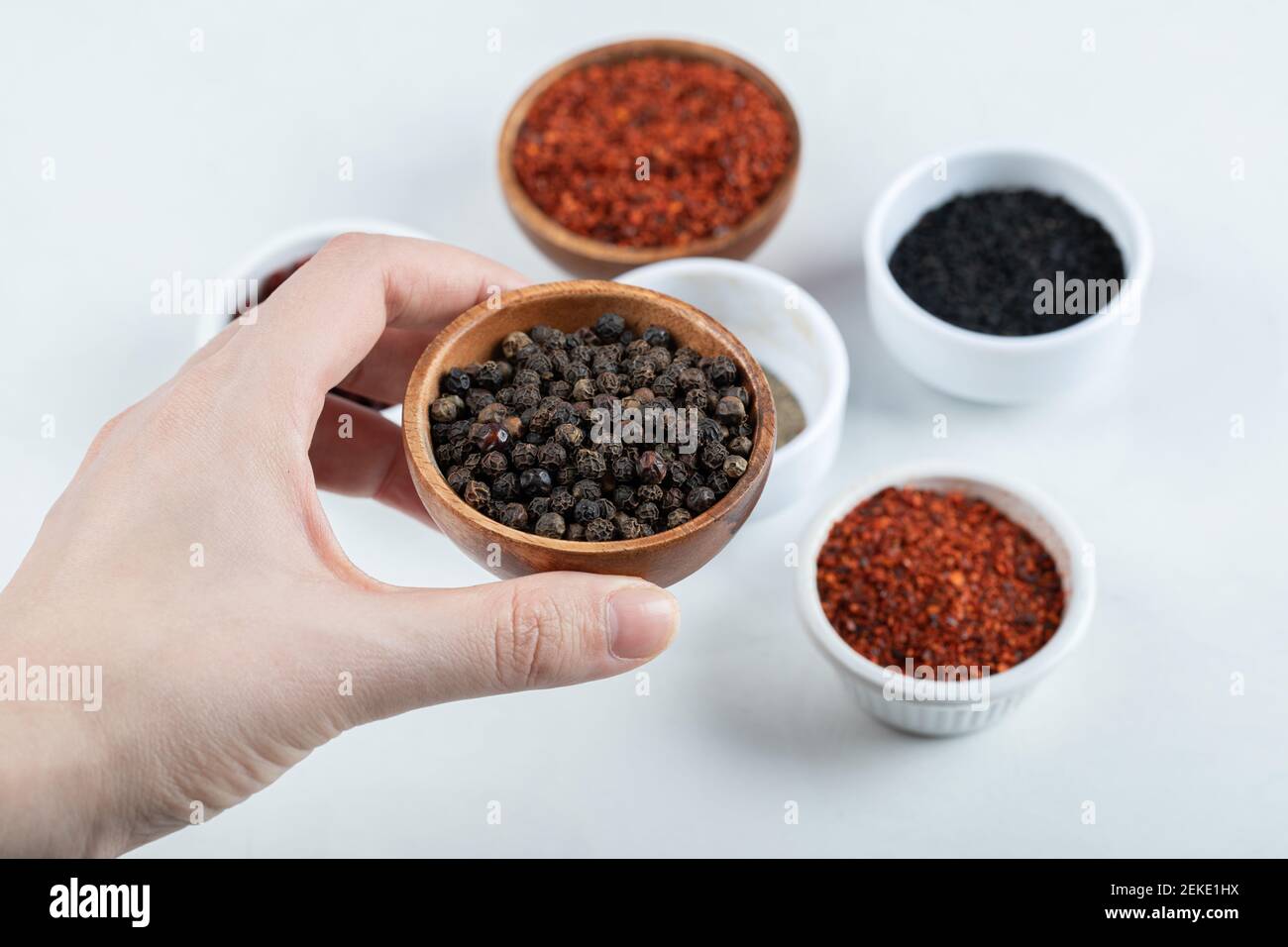 Tenere a mano una ciotola di argilla piena di pepe secco. Foto di alta qualità Foto Stock