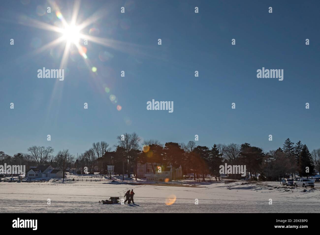 Port Sanilac, Michigan - i pescatori di ghiaccio trascinano la loro attrezzatura a riva dopo aver pescato sul ghiaccio del porto di Port Sanilac sul lago Huron. Foto Stock