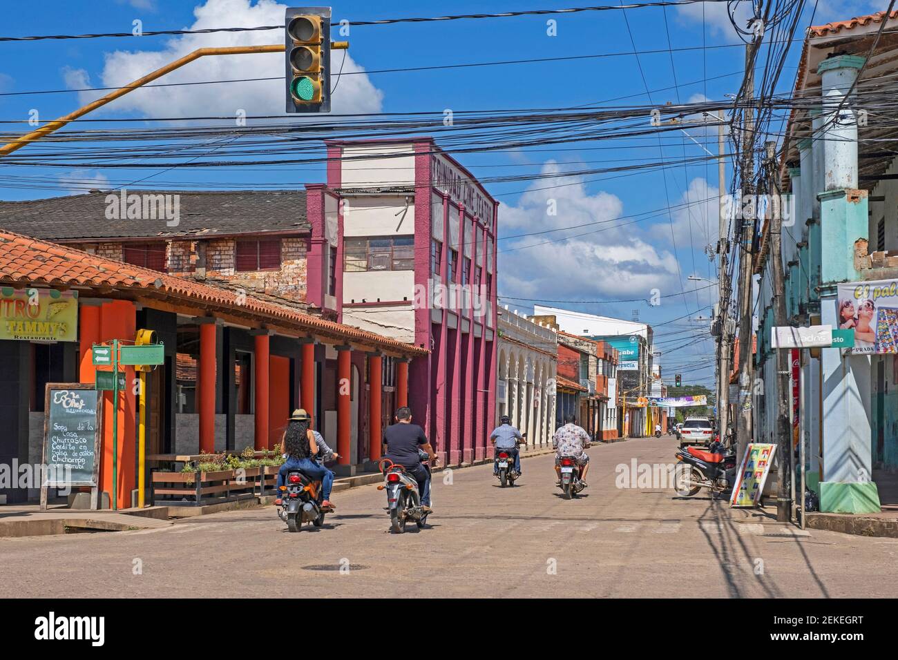 Streetscene che mostra boliviani su moto nel centro coloniale della città di Trinidad in Amazzonia, Provincia di Cercado, Dipartimento di Beni, Bolivia Foto Stock
