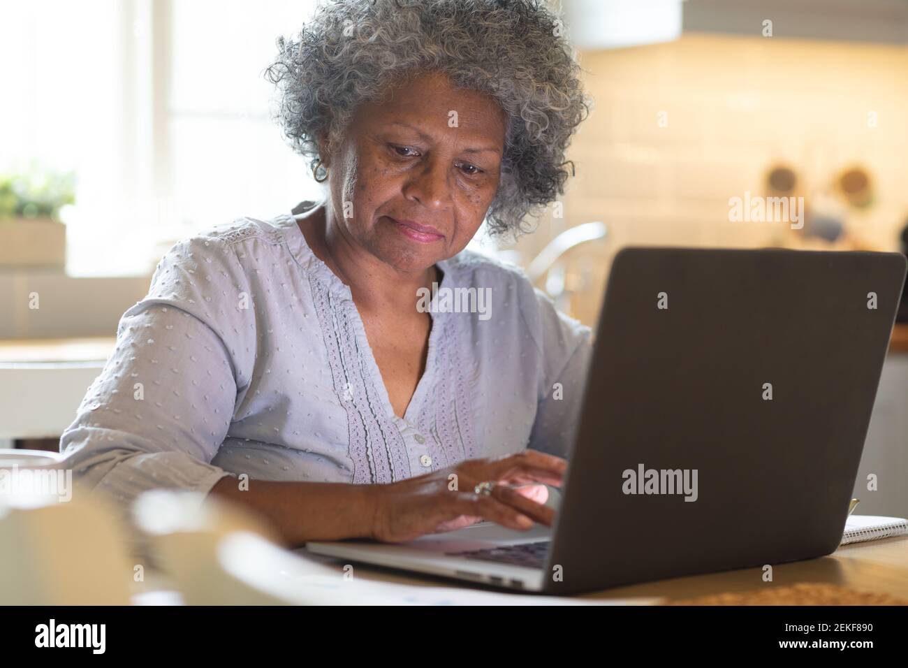 Donna anziana afro-americana che usa il computer portatile a casa Foto Stock
