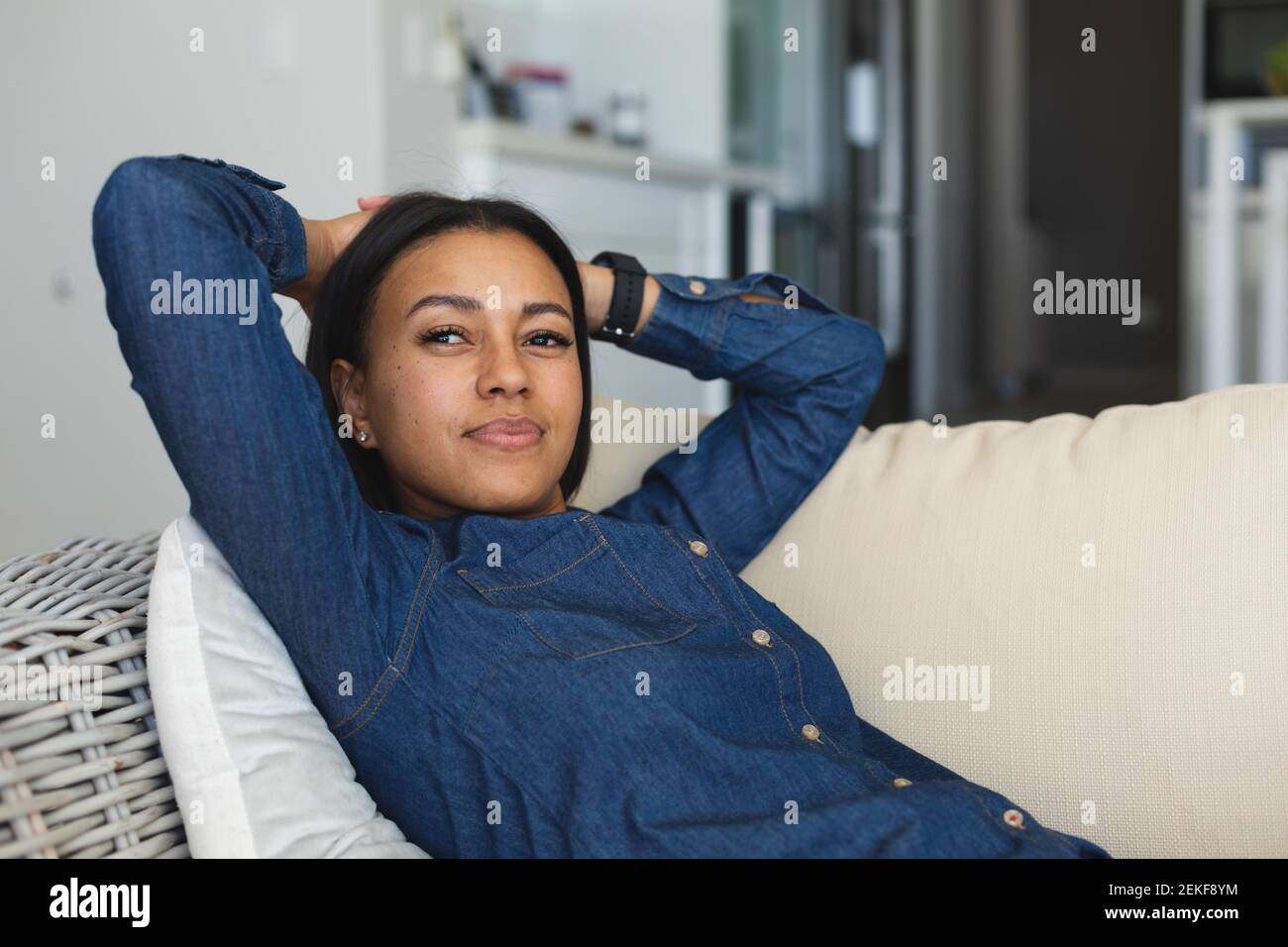 Donna afroamericana sdraiata sul divano di casa Foto Stock