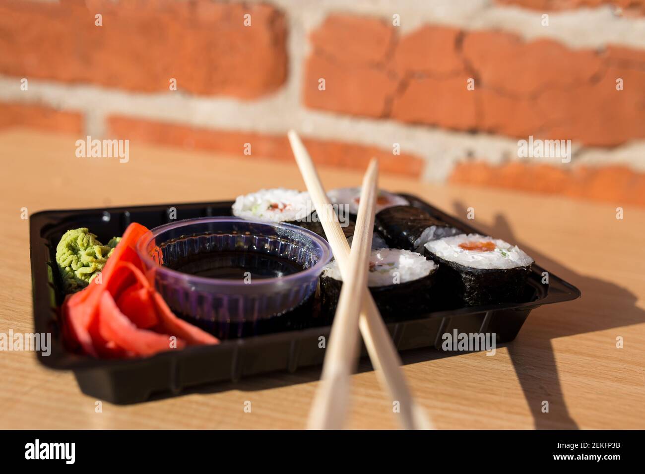 Porzione di sushi confezionata in una scatola di plastica da asporto. Foto Stock