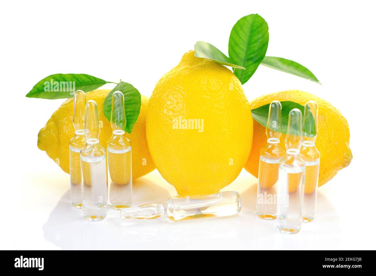 Vitamina C. prevenzione dell'immunità da virus. Siero con vitamina C. Set di fiale trasparenti, limoni frutti con foglie verdi su sfondo bianco Foto Stock