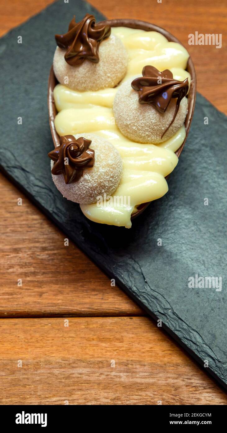 Uovo di pasqua al cioccolato sopra la pietra nera Foto Stock
