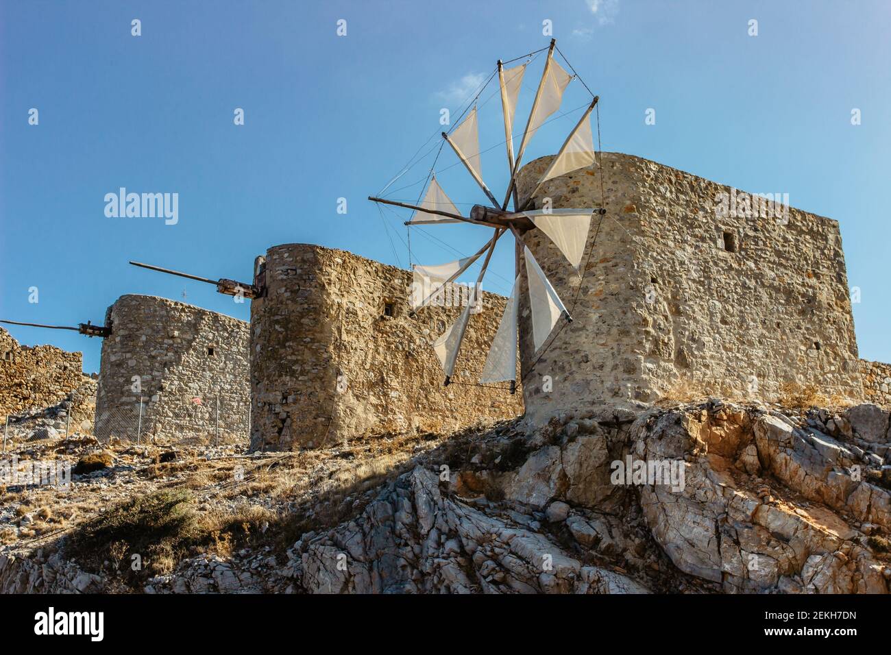 Tranquillo altopiano di Lassithi famoso per i vecchi mulini a vento in pietra, Creta, Grecia. Abbandonati iconici mulini a vento Circondato da picchi rocciosi selvaggi. Visita turistica a Mediter Foto Stock