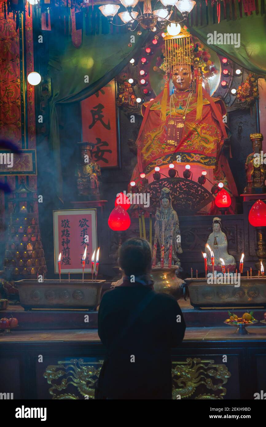 Hong Kong, Cina. Un adoratore inginocchiato di fronte alla divinità nel tempio di Tin Hau a Yau ma Tei, Kowloon. Questo tradizionale tempio cinese dove Tin Hau Foto Stock