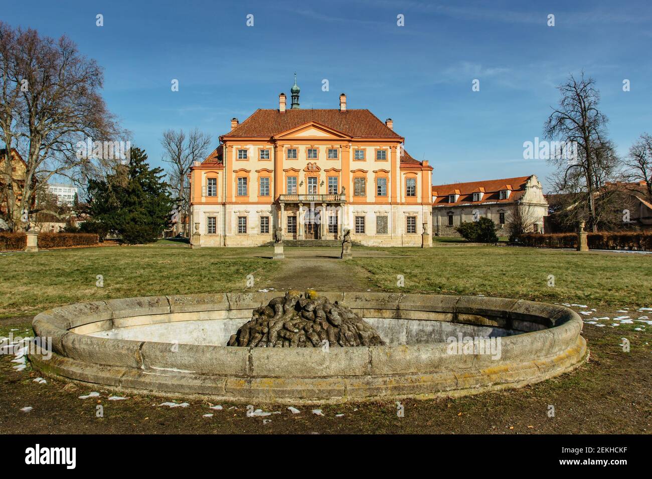 Libechov, antico castello barocco abbandonato nel centro della Boemia, Repubblica Ceca. Edificio romantico con balcone, facciata rossa e fontana vuota nel vicino parco. Foto Stock