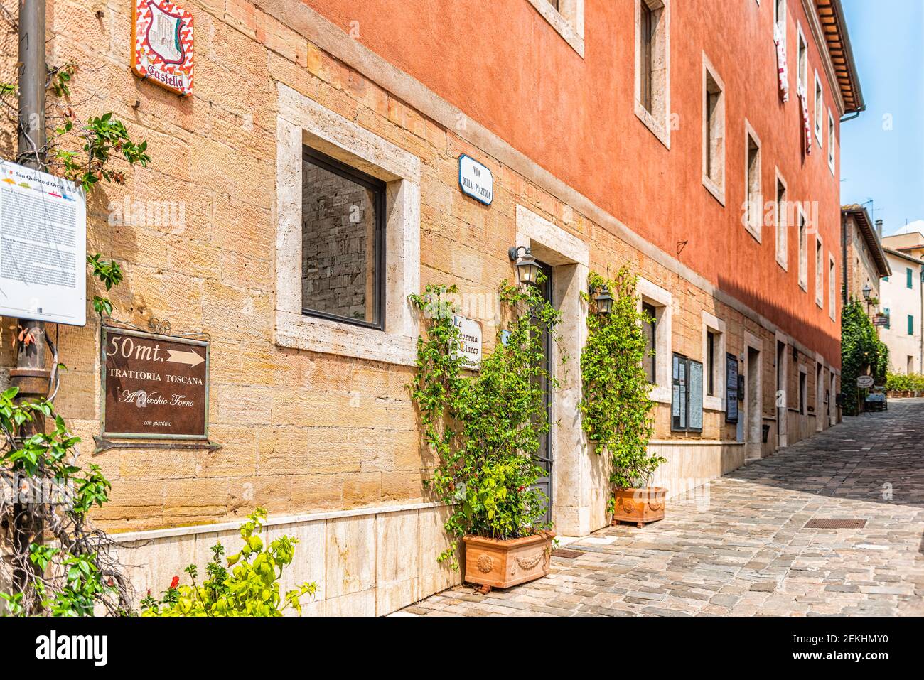 San Quirico D'Orcia, Italia - 26 agosto 2018: Strada colorata in piccolo borgo storico in Toscana durante la soleggiata giornata estiva segno per la caffetteria ristorante Foto Stock