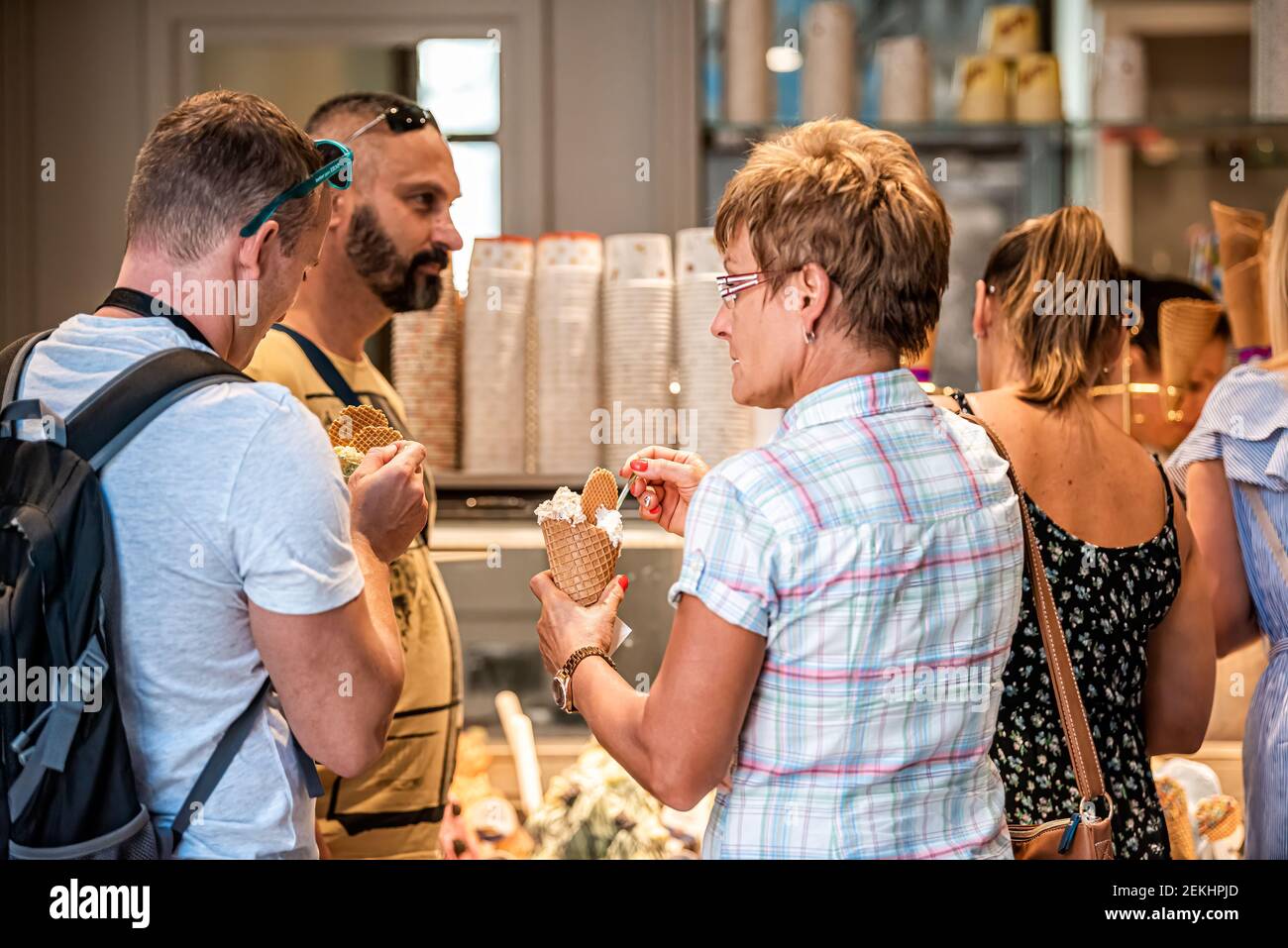 Siena, Italia - 27 agosto 2018: Due candidi che mangiano coni gelato con cucchiai in via italiana nel villaggio storico della Toscana uomo donna Foto Stock