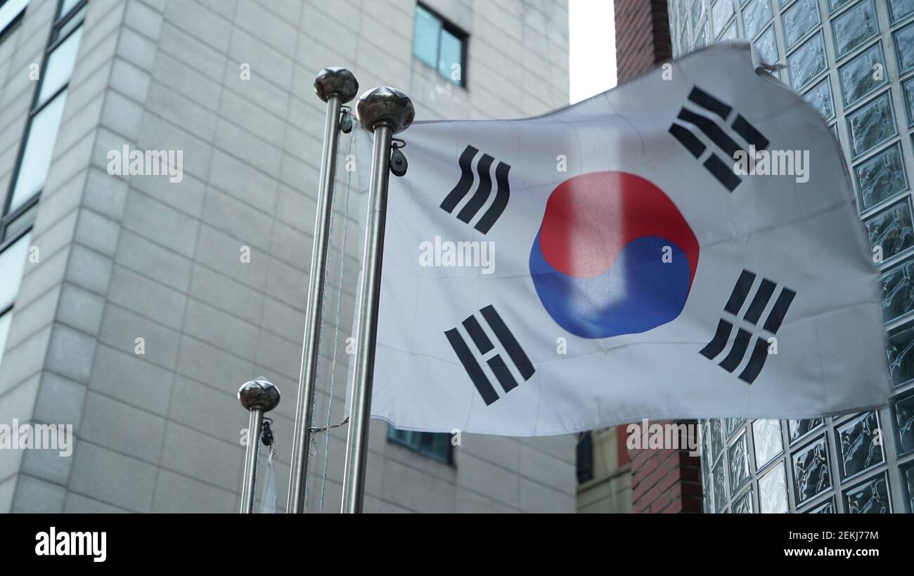 Bandiera della Corea del Sud che batte nel vento di fronte un edificio Foto Stock