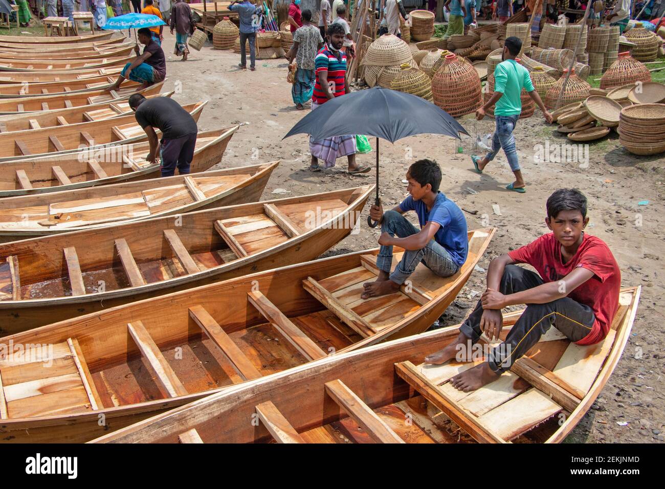 Piccole barche di legno sono allineate per la vendita in un mercato delle  barche, come la vendita di questa tradizionale barca di legno è trafficata  durante il monsone per soddisfare la domanda