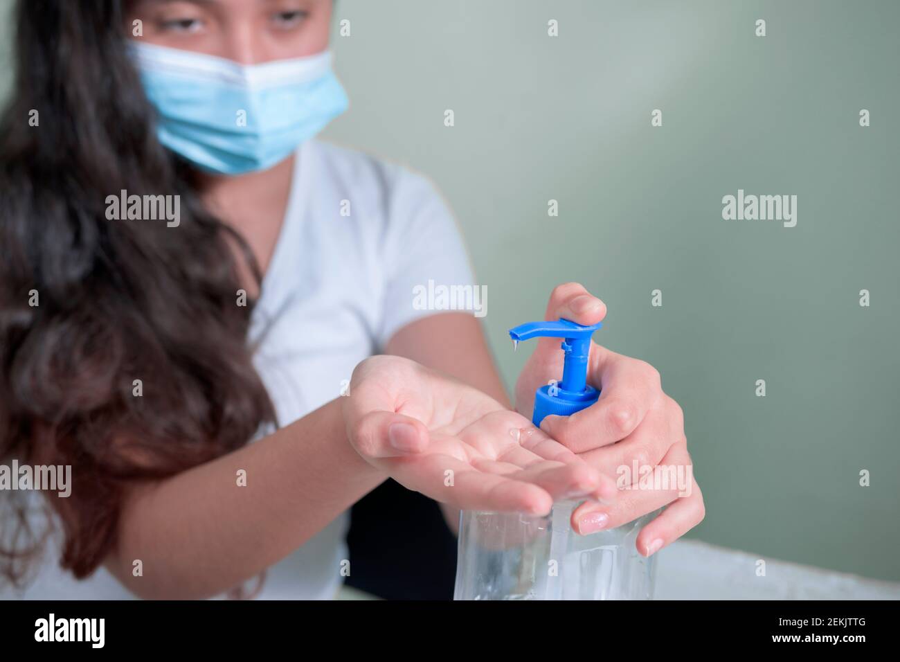 adolescente che mette gel antibatterico sulle mani Foto Stock