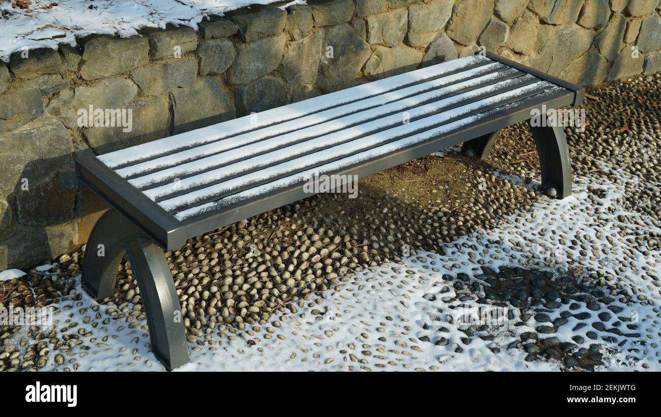 Panchine in legno innevato sul sentiero per escursioni invernali Foto Stock