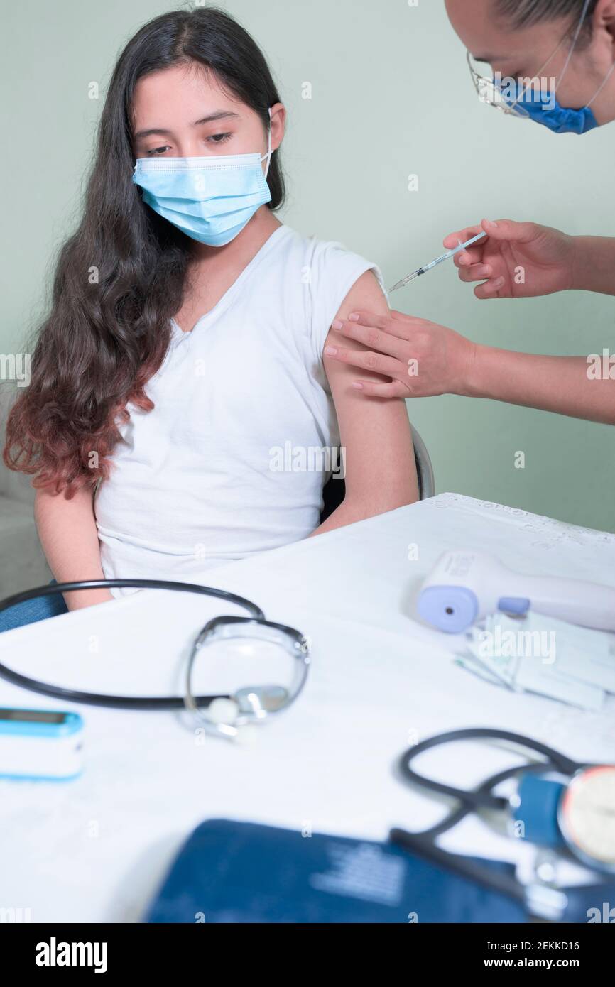 iniezione di vaccino ad adolescenti in pandemia Foto Stock