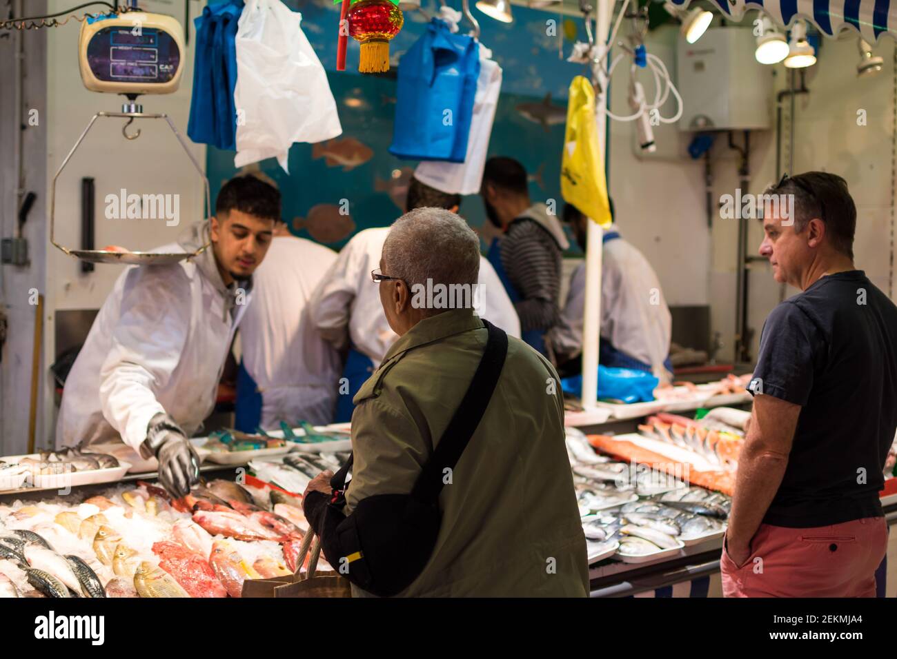 Birmingham, Regno Unito; 08 03 2019: Uomini che fanno lo shopping nel mercato del pesce (fishmonger's) con giovani arabi come assistenti di negozio. Uomo anziano Foto Stock