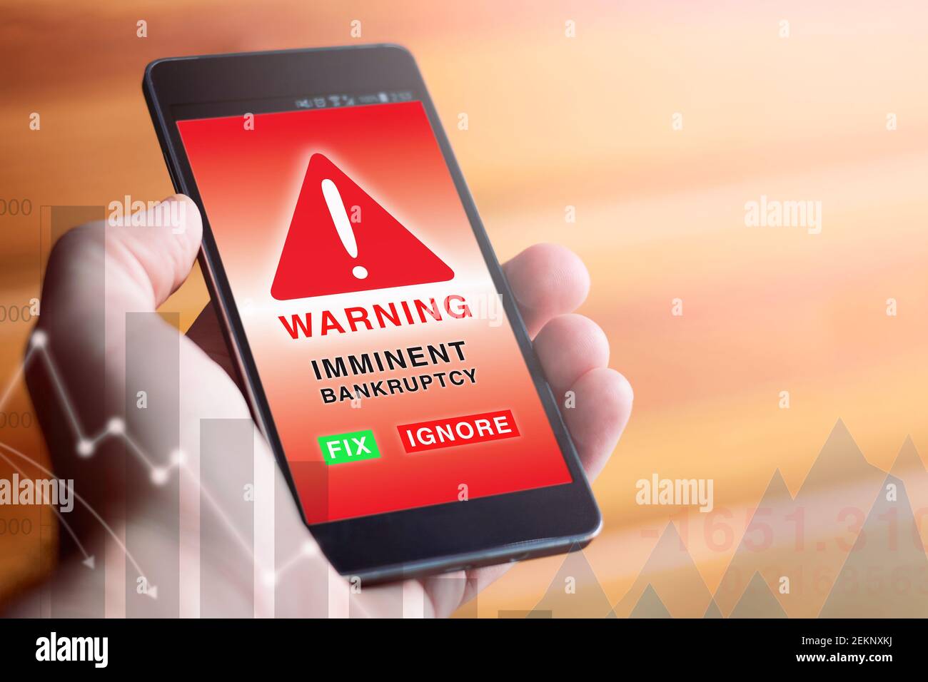 Closeup di mano maschile che tiene moderno telefono cellulare con schermo rosso che mostra il simbolo di avvertimento e la parola con il testo 'IMMINENTE FALLIMENTO'. Foto Stock