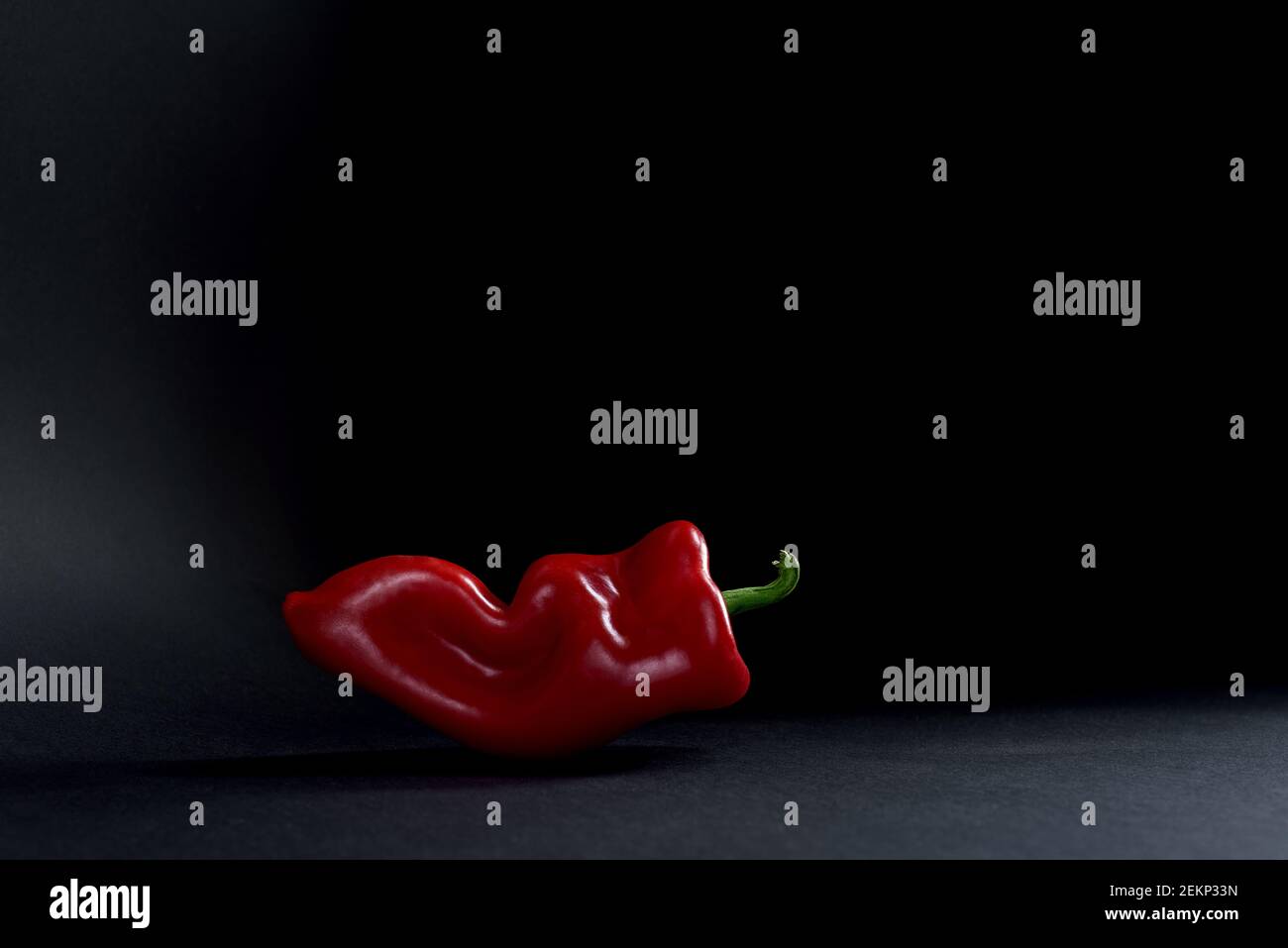 Una paprika rossa su sfondo nero Foto Stock