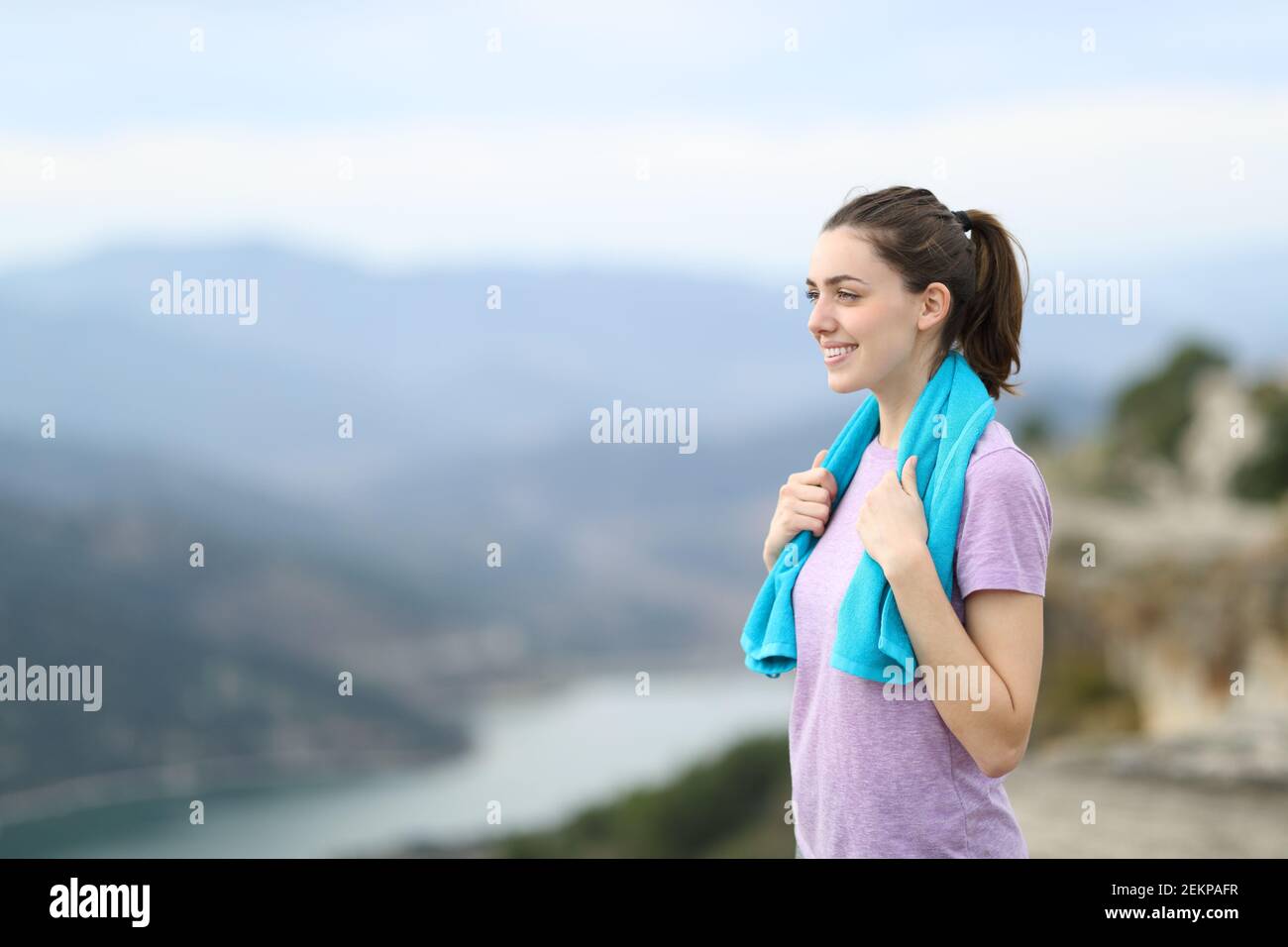 Buon corridore contemplando le viste dopo lo sport da una scogliera dentro la montagna Foto Stock