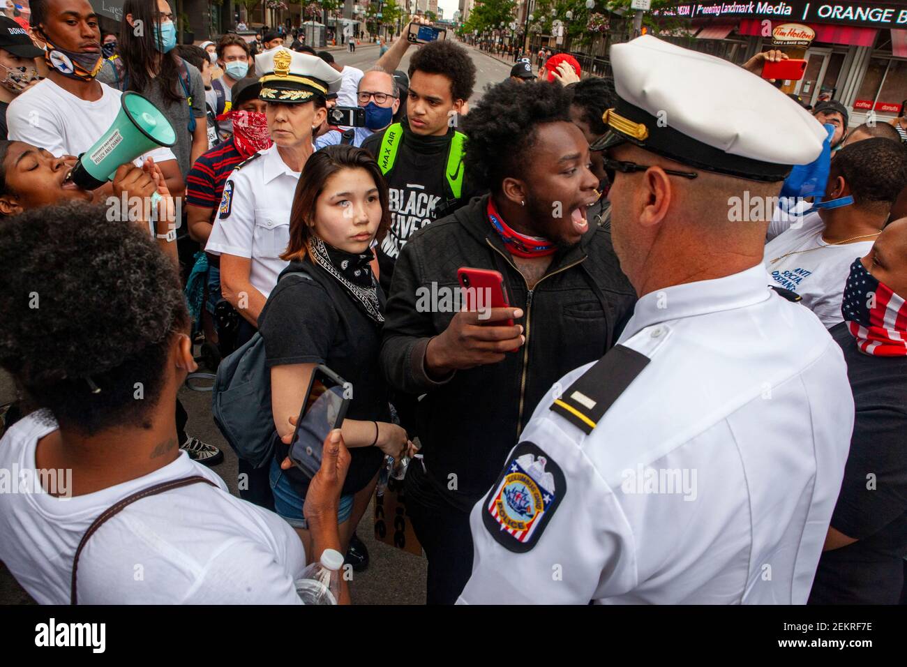 Columbus, Ohio, Stati Uniti. 1 giugno 2020. Brooke Lam, 19 anni, di Delaware, Ohio, guarda Columbus Police Officer che ha marciato con i manifestanti attraverso il centro della città per raggiungere l'Ohio Statehouse.grandi gruppi di manifestanti si sono riuniti di fronte all'Ohio Statehouse per protestare contro la brutalità della polizia, E l'uccisione di George Floyd da parte dell'ufficiale di polizia di Minneapolis Derek Chauvin il 25 maggio 2020. Le persone hanno protestato dalle 17:00 alle 10:30 quando i manifestanti sono stati dispersi dalla polizia di Riot per aver infranguto il coprifuoco delle 22:00. Il giorno della protesta ha coinvolto momenti marcati di marcia, canti, rallying e proteste performative Foto Stock