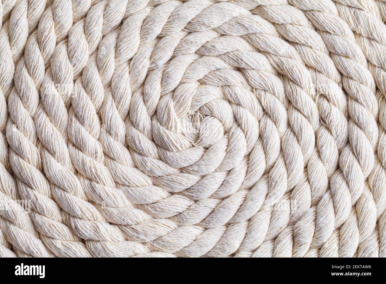 Corda di canapa sprial intrecciata arricciata in uno sfondo a spirale. Foto Stock